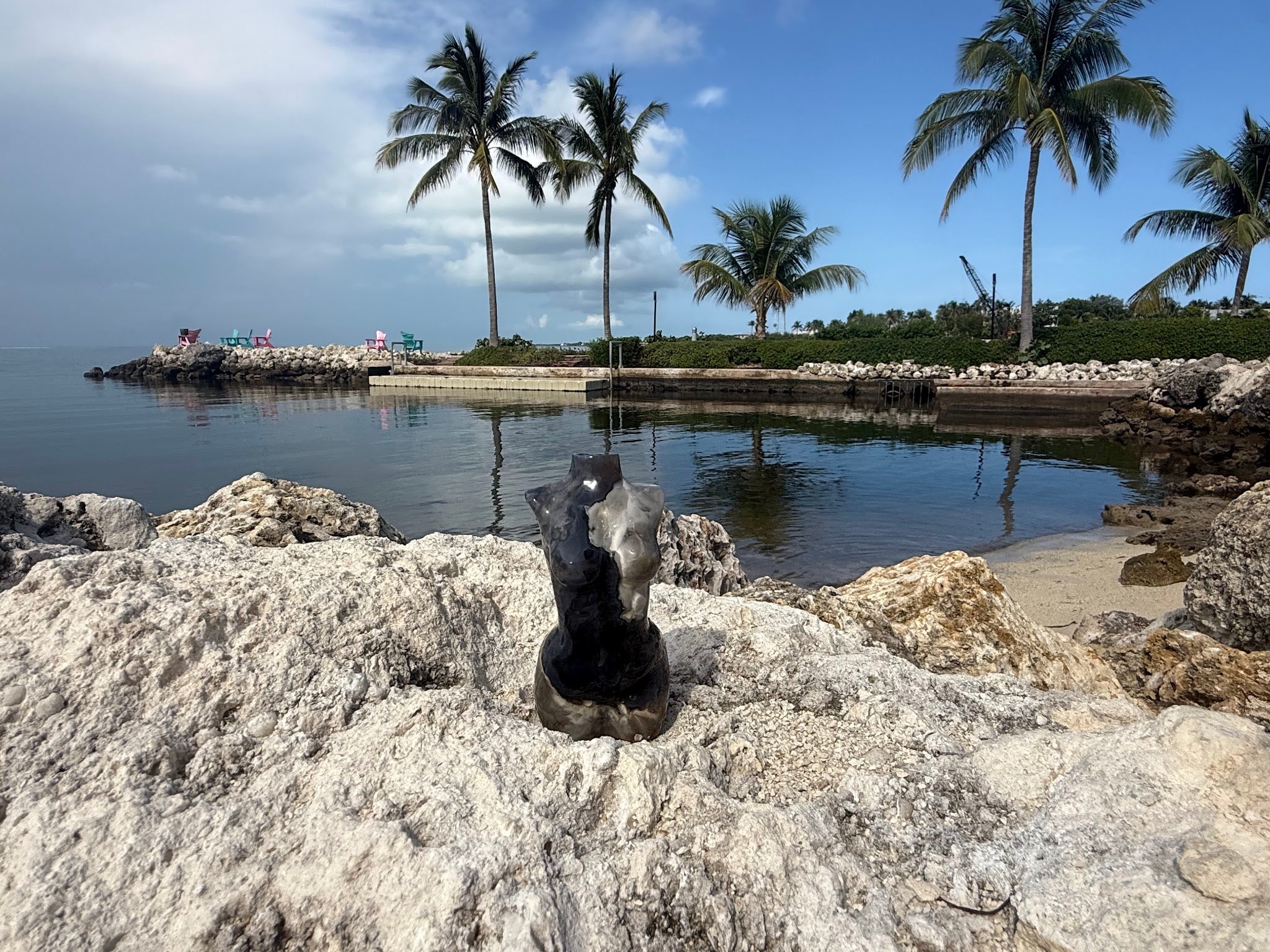 Hand-carved stone goddess statue on beach rocks in the Florida Keys